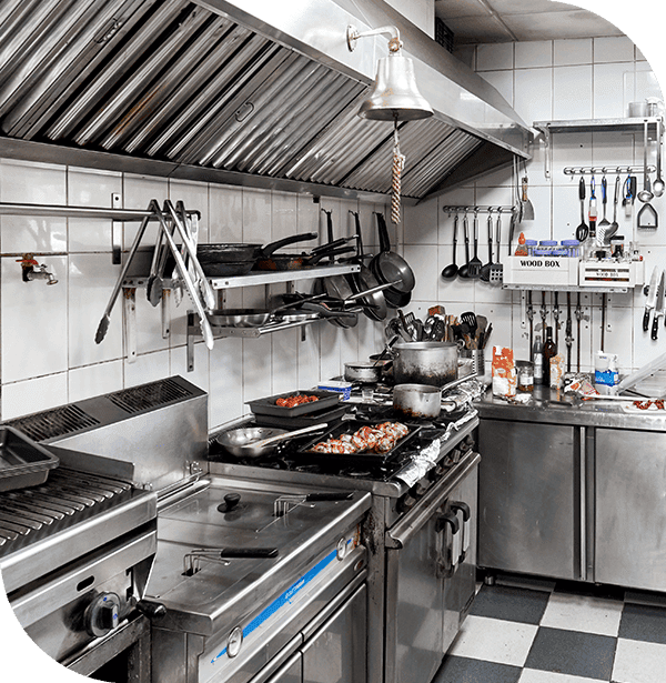 a huge stainless steel commercial kitchen with food on the stove and dishes in the sink